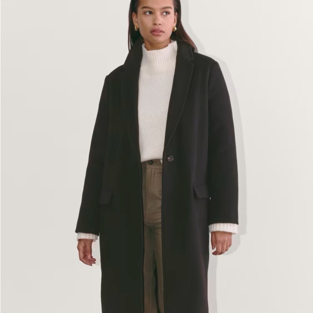Black oversized trench coat with full length relaxed fit and wide lapel collar